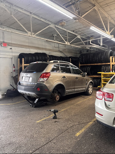 Inside the shop at 2007 W National Ave, with tire racks and a vehicle on a lift
